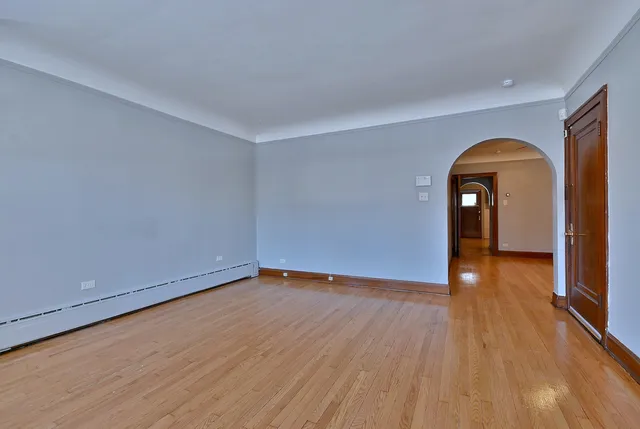 a view of a room with wooden floor and a window