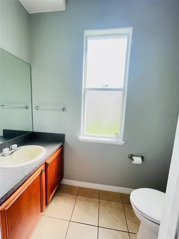 a bathroom with a granite countertop sink toilet and a mirror
