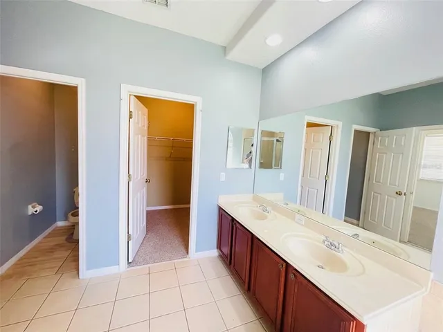 a spacious bathroom with a double vanity sink a mirror and a shower