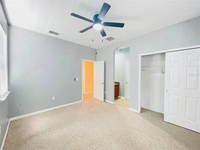 a view of an empty room with a ceiling fan