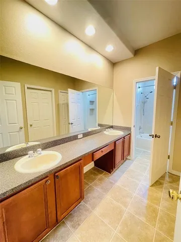 a spacious bathroom with a double vanity sink a mirror and a bathtub