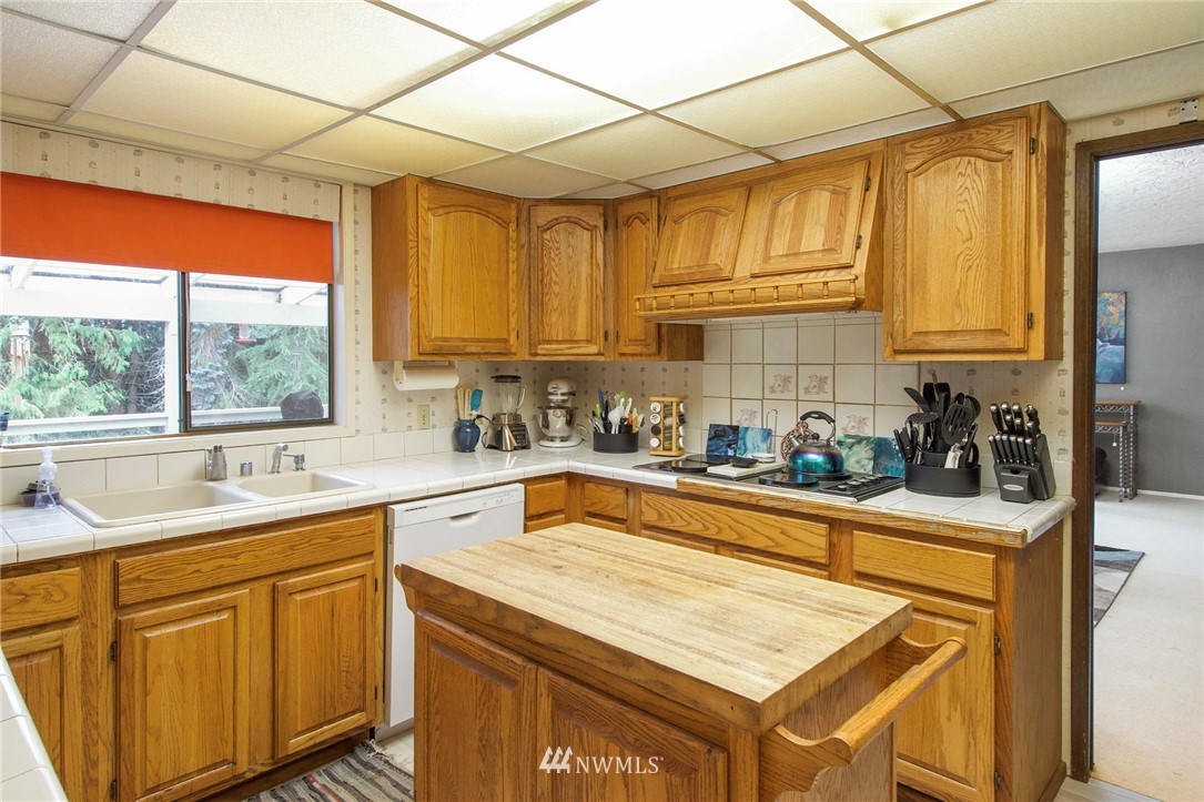1493 Atterberry Road Sequim, WA 98382 - Photo 11 of 40 a kitchen with a sink window and cabinets