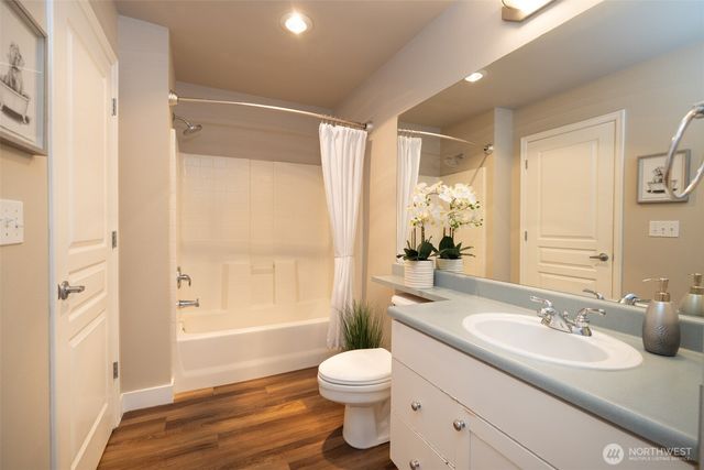 a bathroom with a granite countertop sink toilet and shower