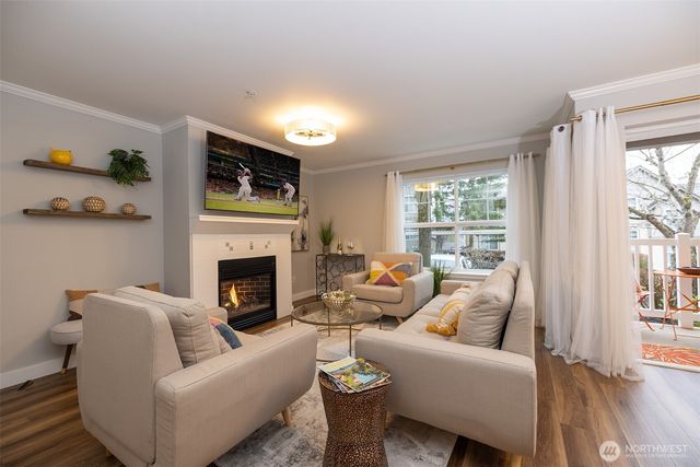 a living room with furniture a fireplace and a floor to ceiling window