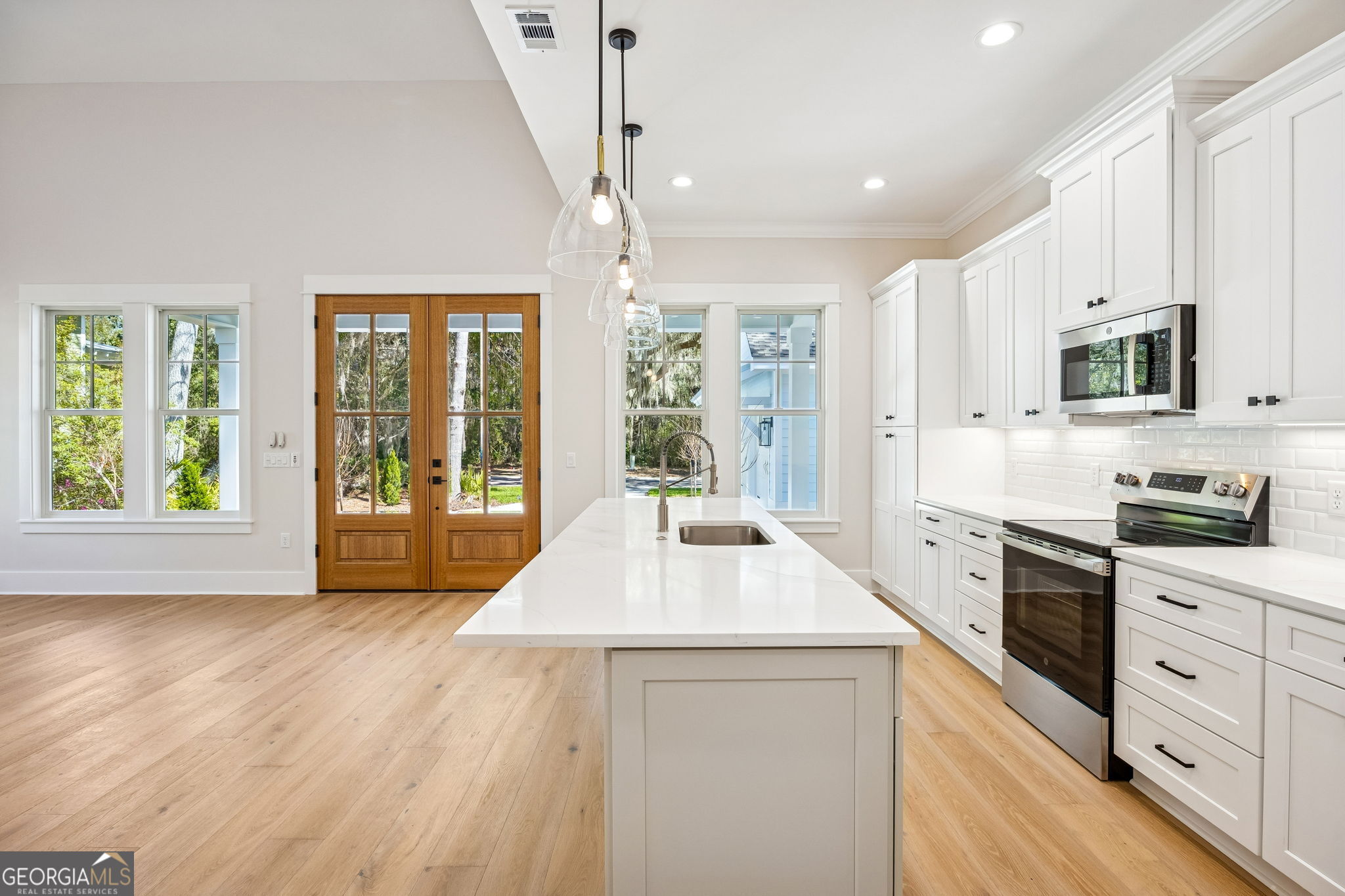 308 Anchor Way St. Marys, GA 31558 - Photo 28 of 55 a kitchen with stainless steel appliances kitchen island granite countertop a stove a sink and white cabinets with wooden floor