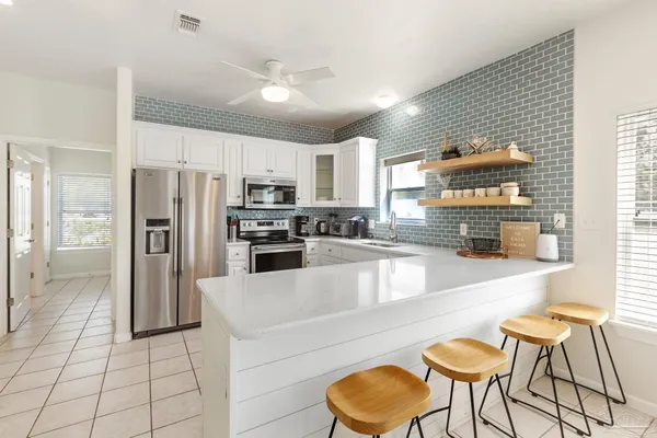 a dining hall with stainless steel appliances kitchen island granite countertop a granite counter tops and a view of living room