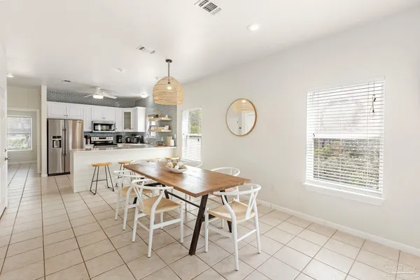 a living room with furniture a rug and kitchen view