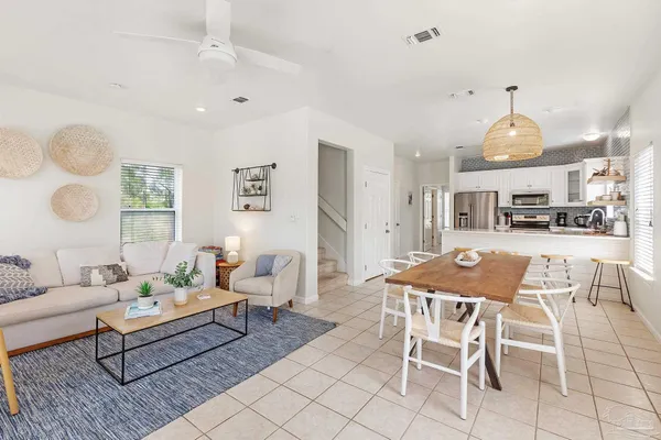 a living room with furniture a flat screen tv and a large window