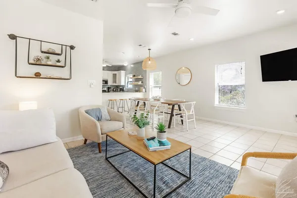 a living room with furniture a dining table and a window