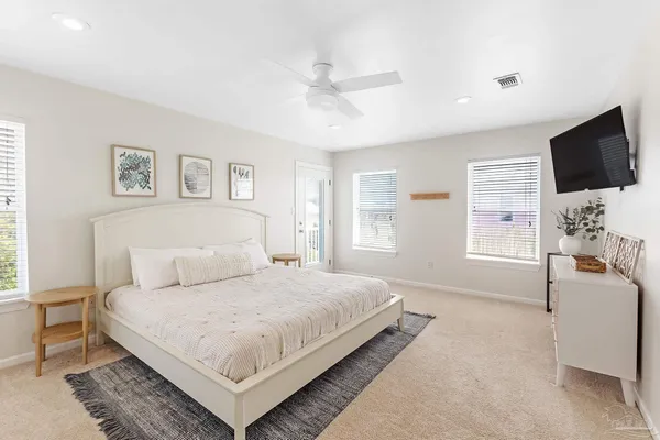 a spacious bedroom with a bed and a flat screen tv