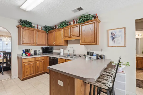 a kitchen with granite countertop a stove a sink dishwasher and cabinets with wooden floor