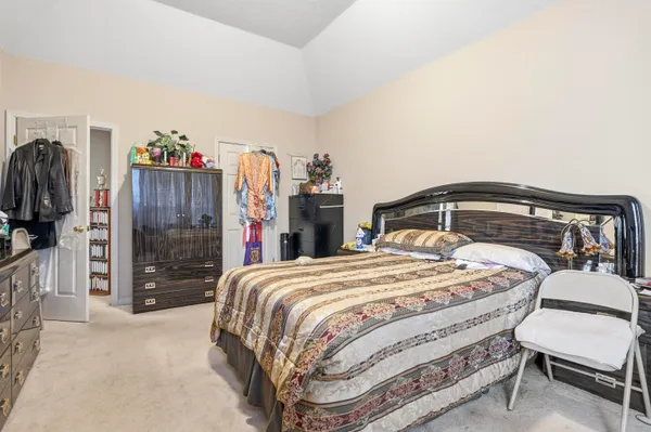 a bedroom with a bed a walk in closet and a bathroom