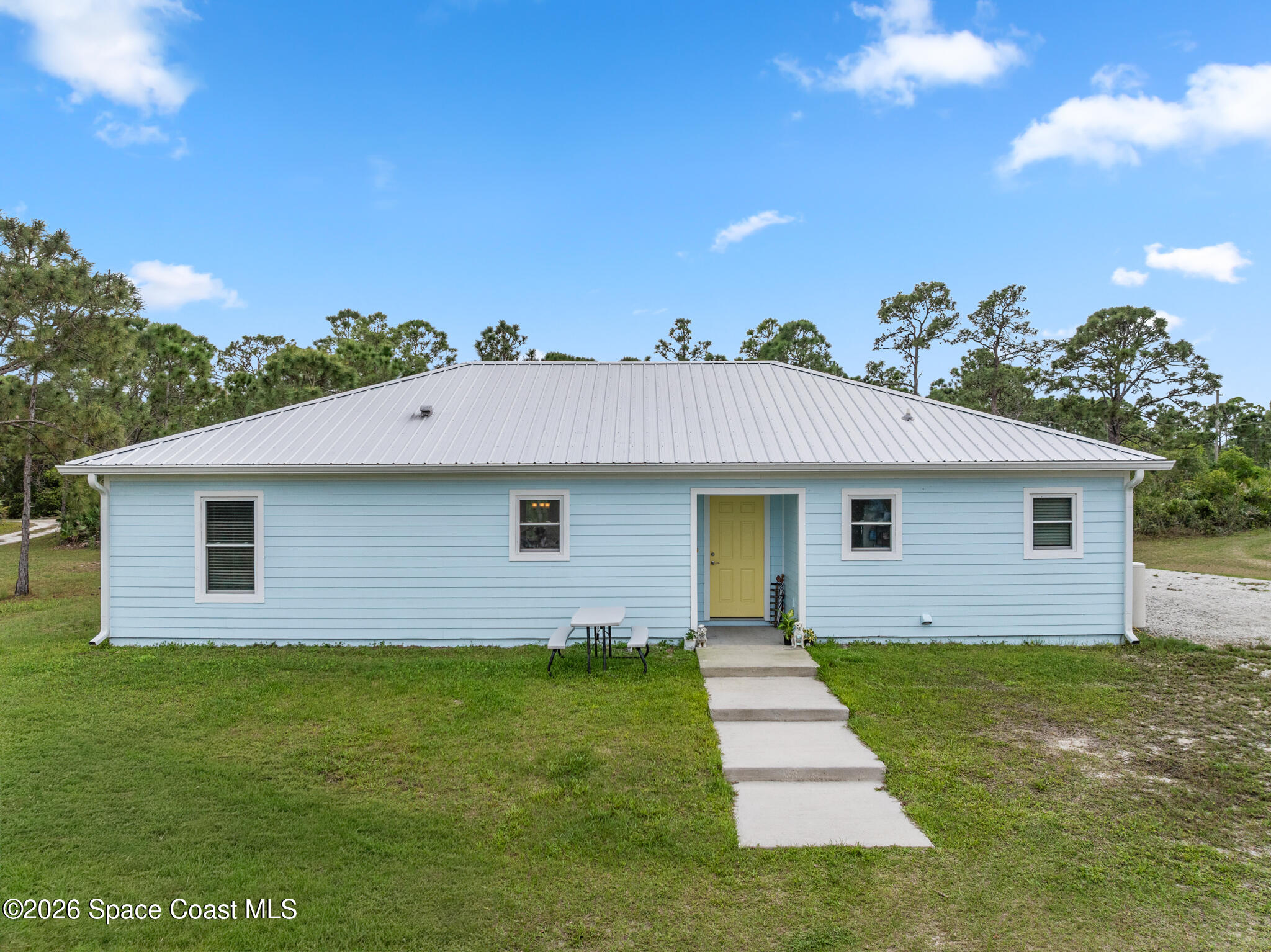 4310 Sand Point Road Grant Valkaria, FL 32949 - Photo 1 of 50 a front view of a house with a garden