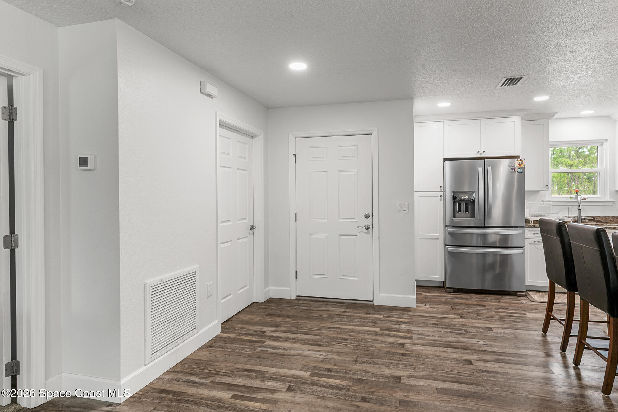 4310 Sand Point Road Grant Valkaria, FL 32949 - Photo 13 of 50 a view of kitchen with refrigerator microwave and wooden floor
