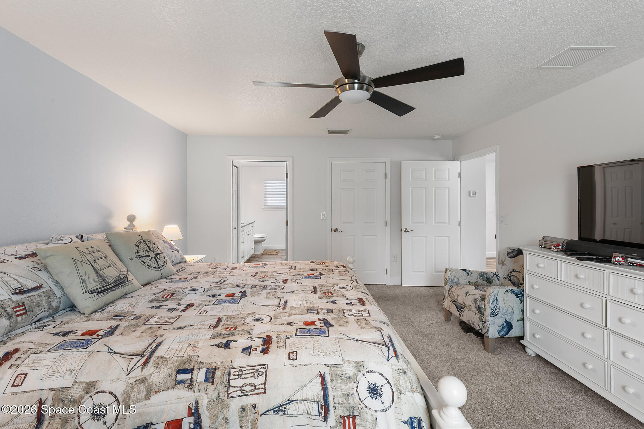 4310 Sand Point Road Grant Valkaria, FL 32949 - Photo 18 of 50 a bedroom with a bed and a flat screen tv