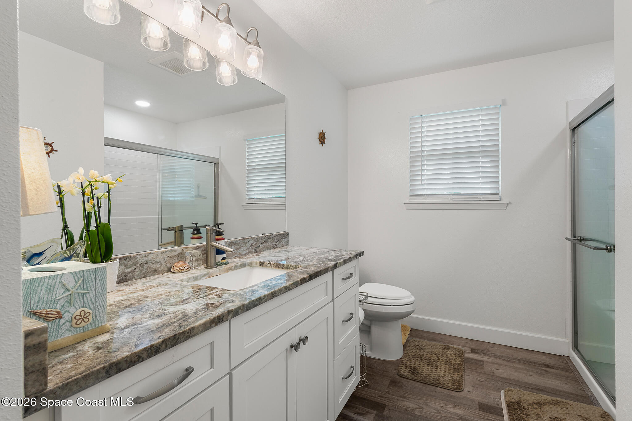 4310 Sand Point Road Grant Valkaria, FL 32949 - Photo 20 of 50 a bathroom with a granite countertop sink a toilet and a mirror