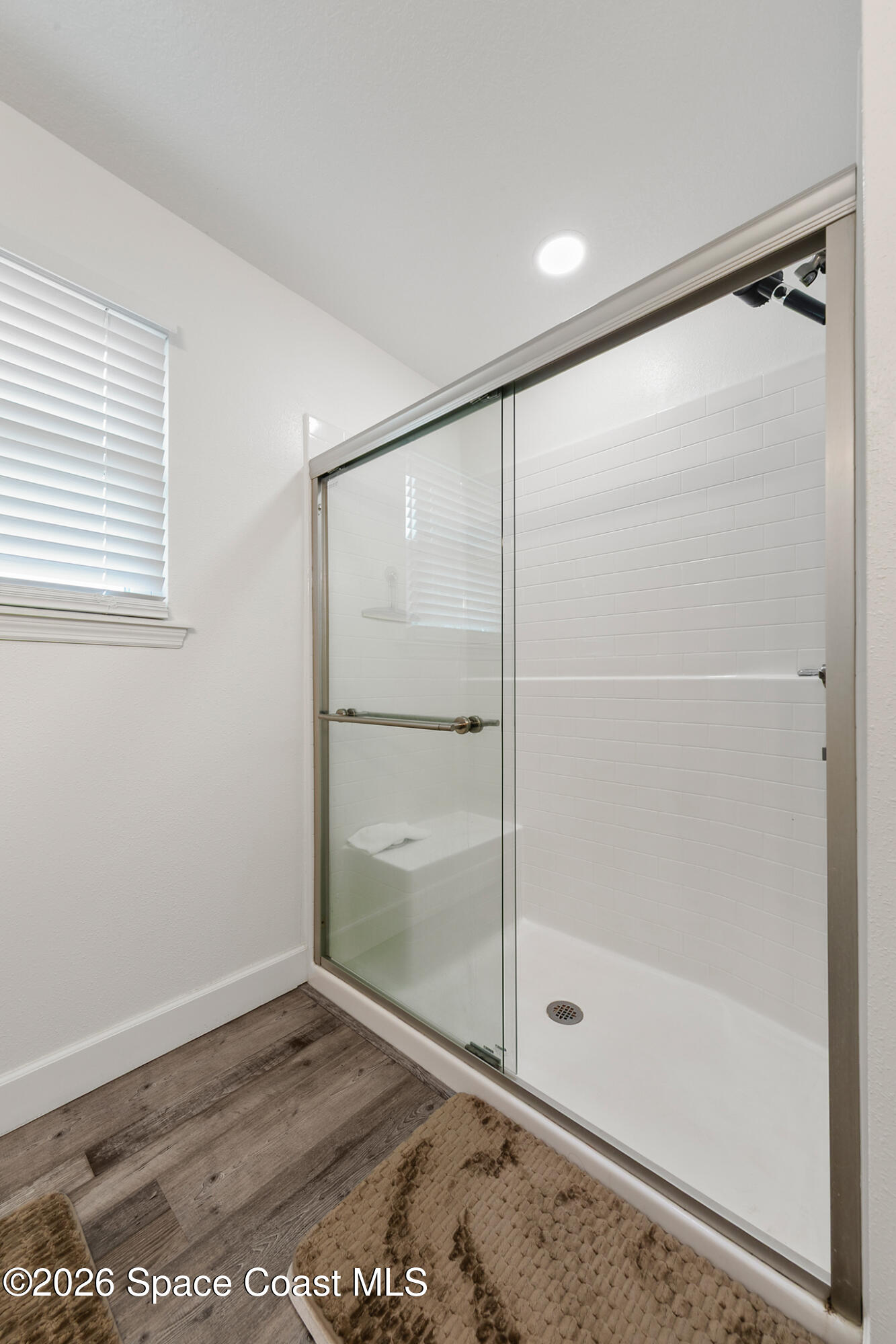 4310 Sand Point Road Grant Valkaria, FL 32949 - Photo 22 of 50 a bathroom with a glass shower door