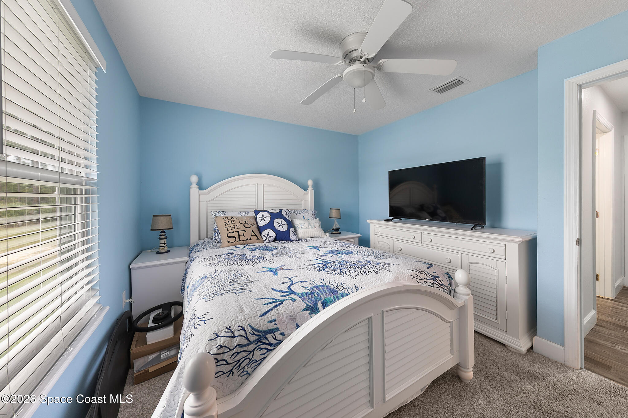 4310 Sand Point Road Grant Valkaria, FL 32949 - Photo 24 of 50 a bedroom with a large bed and a flat tv screen on a dresser