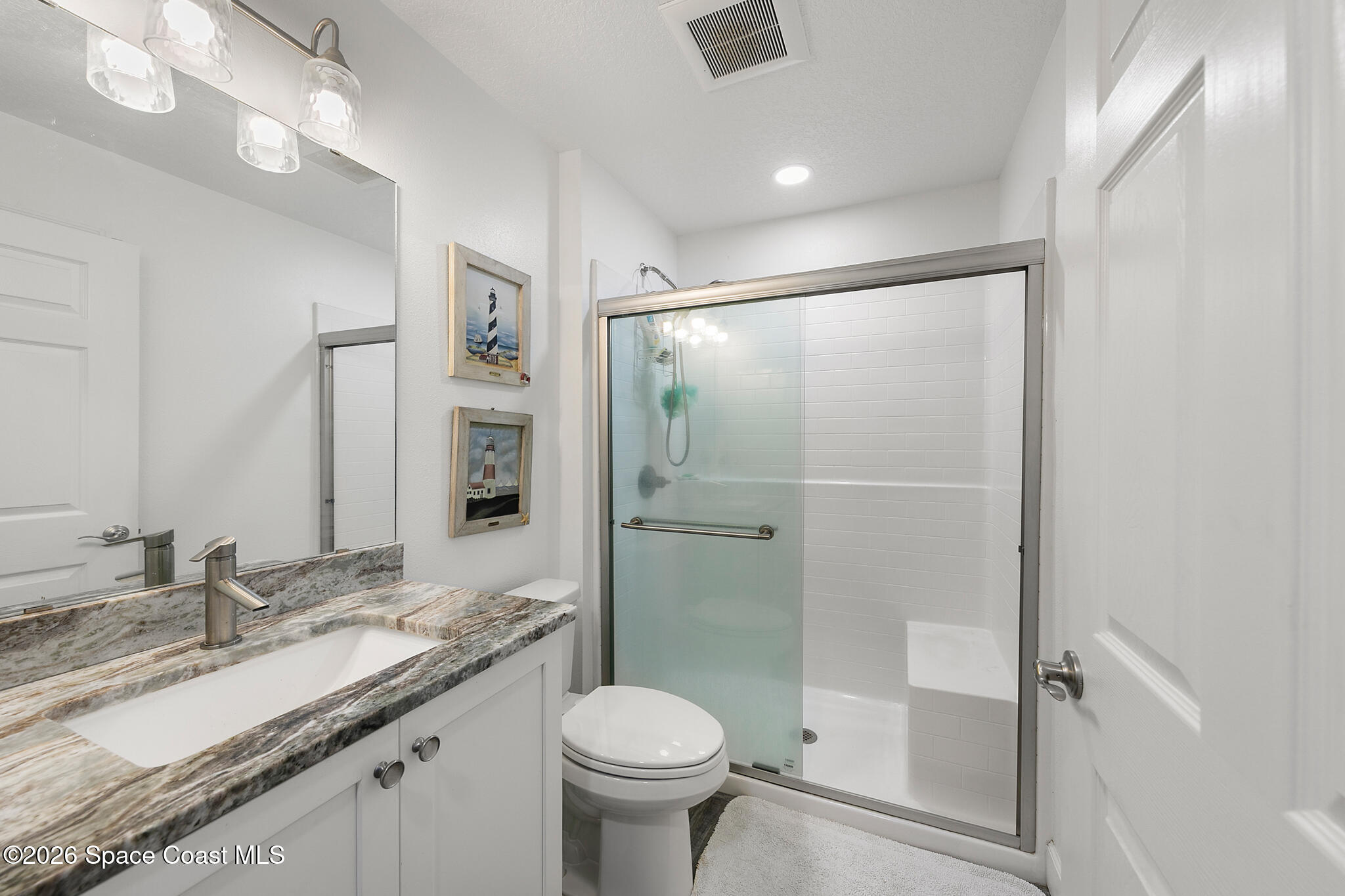 4310 Sand Point Road Grant Valkaria, FL 32949 - Photo 26 of 50 a bathroom with a granite countertop sink toilet and shower
