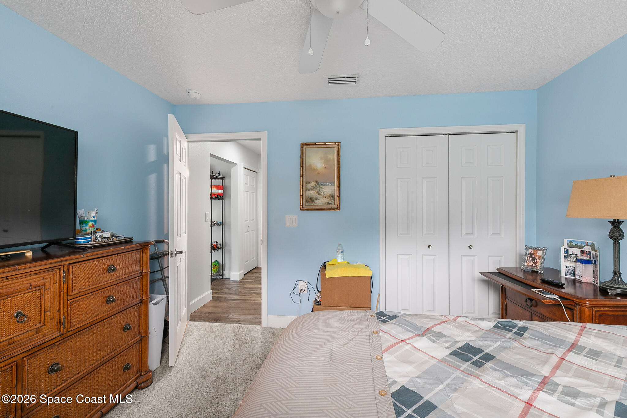 4310 Sand Point Road Grant Valkaria, FL 32949 - Photo 28 of 50 a bedroom with a bed and flat tv screen on the dresser