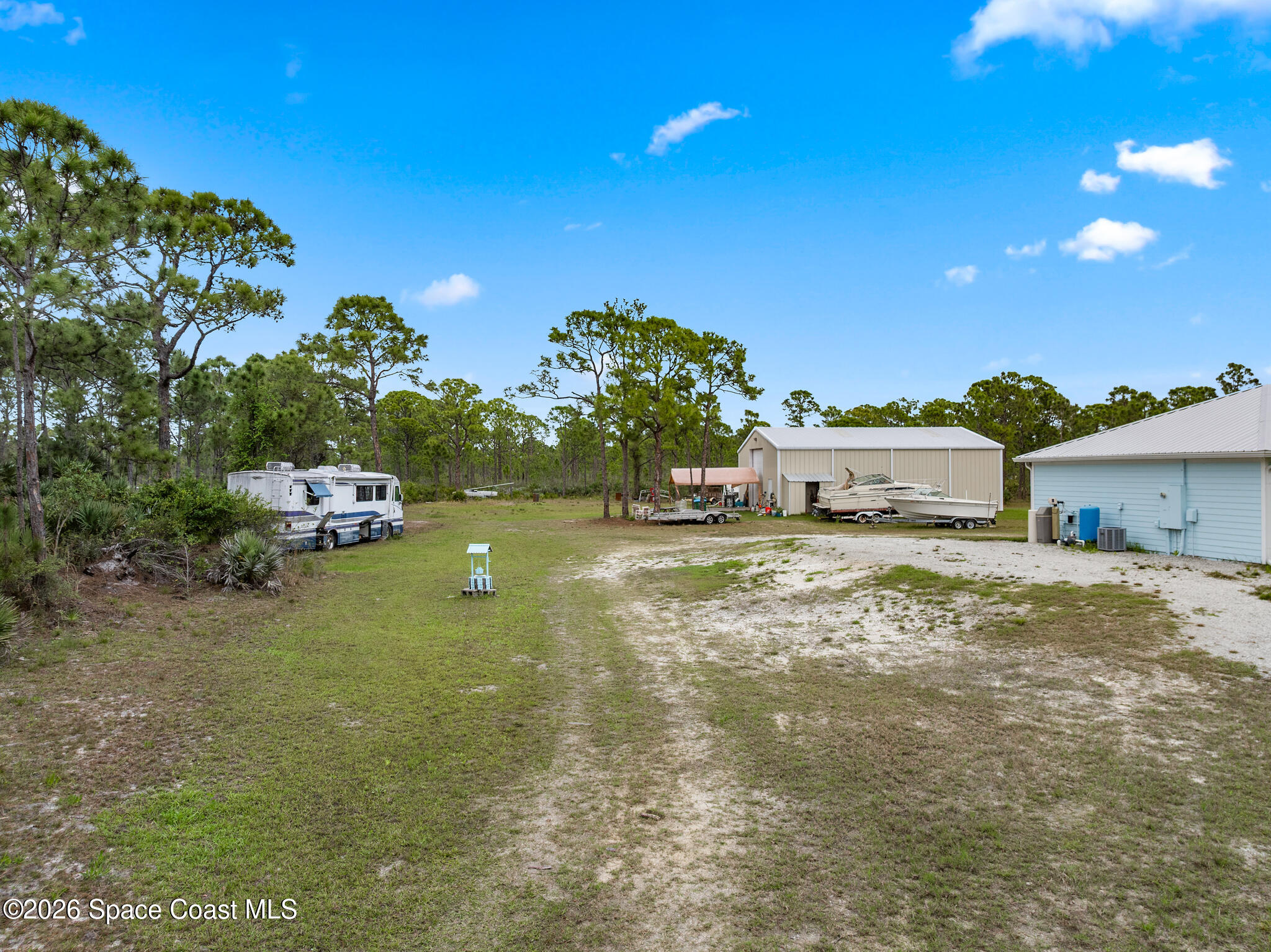 4310 Sand Point Road Grant Valkaria, FL 32949 - Photo 29 of 50 a backyard of a house with table and chairs