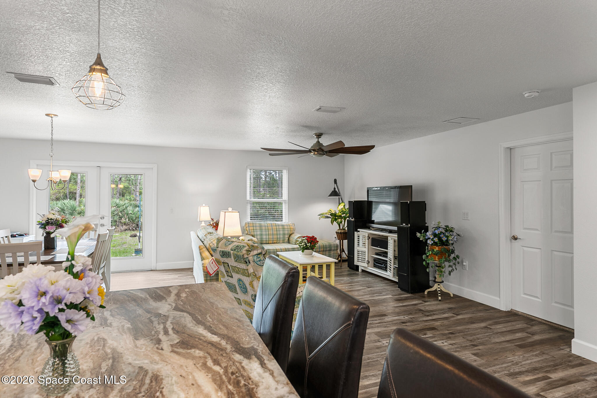 4310 Sand Point Road Grant Valkaria, FL 32949 - Photo 7 of 50 a kitchen with stainless steel appliances granite countertop a stove refrigerator and couches with wooden floor