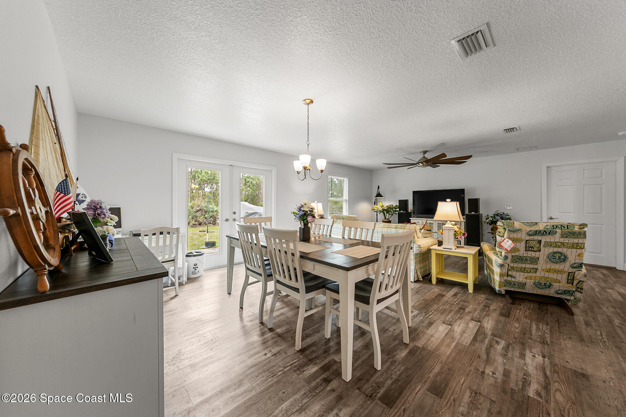 4310 Sand Point Road Grant Valkaria, FL 32949 - Photo 10 of 50 a view of a dining room with furniture window and wooden floor