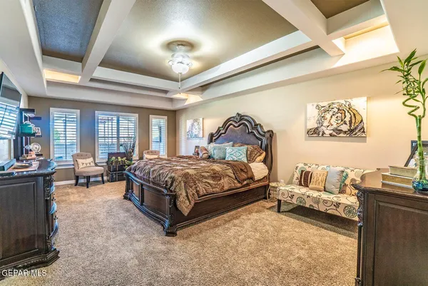 a spacious bedroom with a bed and a chandelier