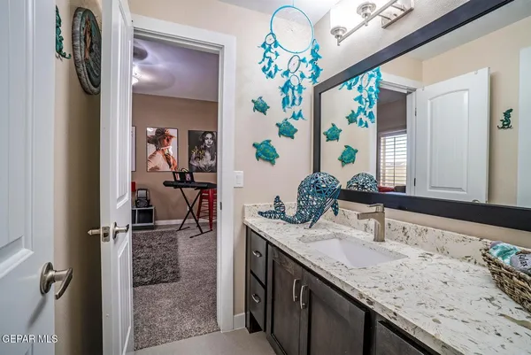 a bathroom with a granite countertop sink and a mirror