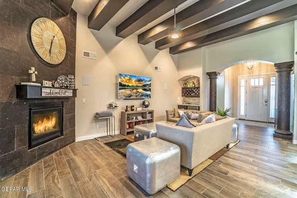 a living room with couches a fireplace with wooden floor