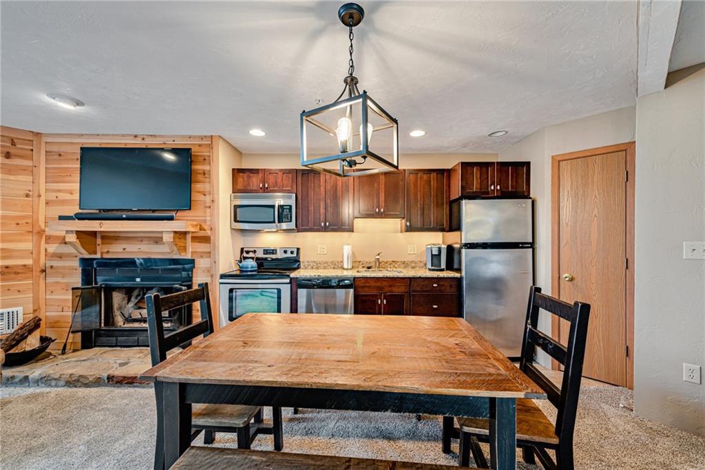 F7 Sunridge Road Champion, PA 15622 - Photo 13 of 25 a kitchen with stainless steel appliances granite countertop a stove a refrigerator a kitchen island a table and chairs
