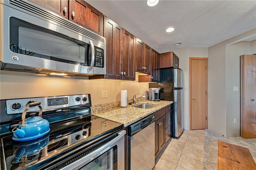 F7 Sunridge Road Champion, PA 15622 - Photo 10 of 25 a kitchen with stainless steel appliances granite countertop a stove microwave and refrigerator