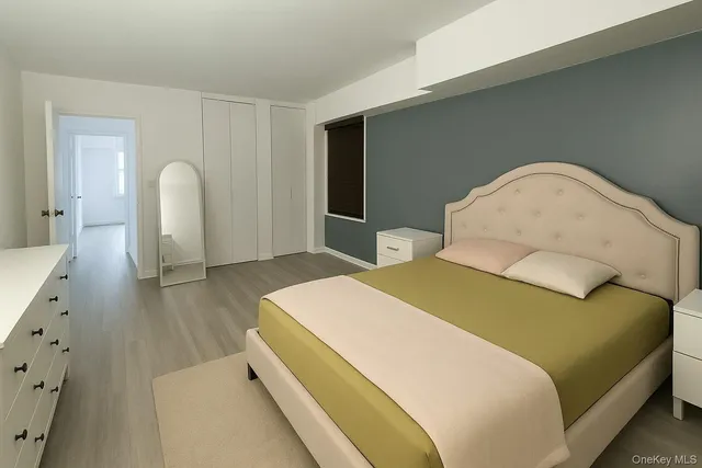 a spacious bedroom with a bed and wooden floor