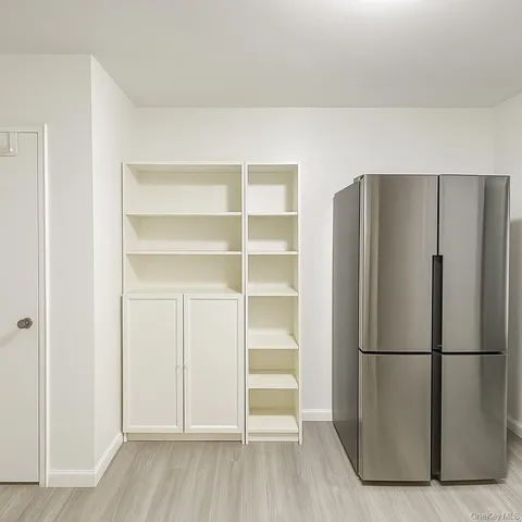 a view of a kitchen with a refrigerator and wooden floor