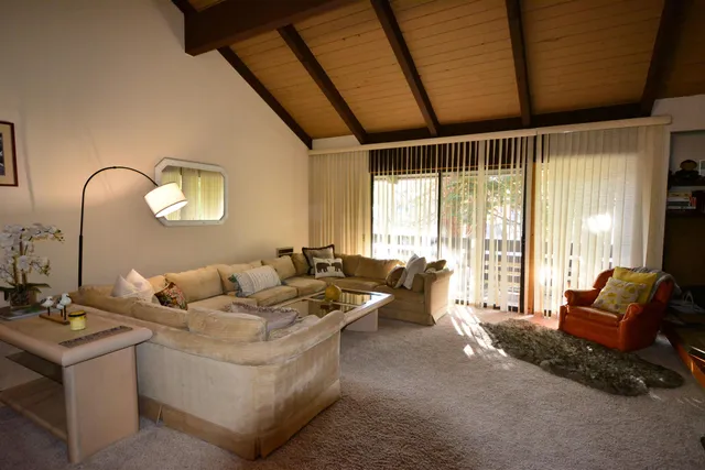 a living room with furniture and large windows