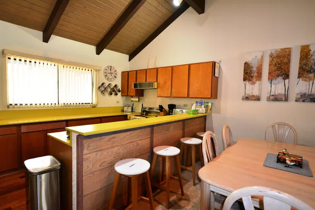 a kitchen with a table chairs sink and wooden floor