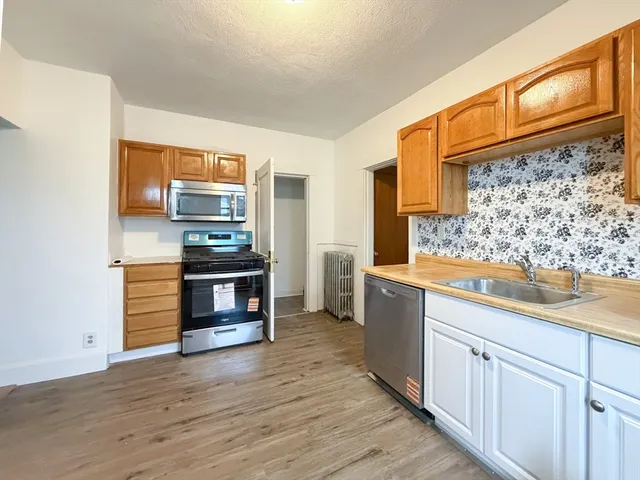 a kitchen with stainless steel appliances kitchen island wooden cabinets and a counter top space