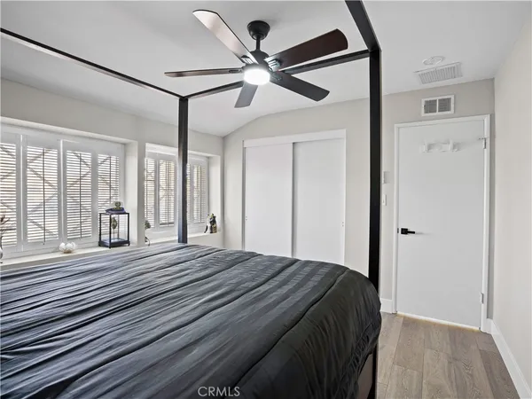 a bedroom with a bed and a large mirror with wooden floor