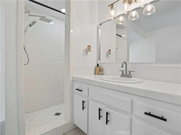 a bathroom with a shower sink and mirror