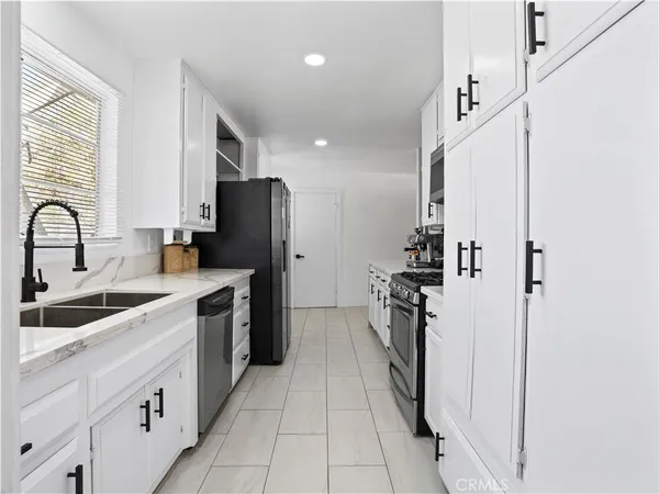 a kitchen with stainless steel appliances granite countertop a refrigerator and a sink