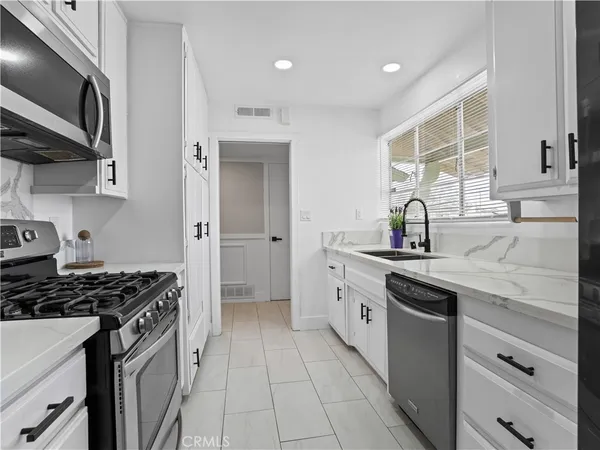 a kitchen with stainless steel appliances a sink stove and cabinets