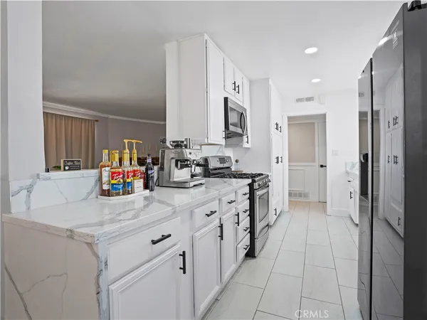 a kitchen with stainless steel appliances kitchen island granite countertop a refrigerator and a sink