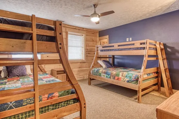 a bedroom with a bed a couch and a flat screen tv