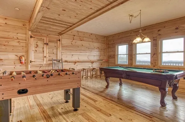 a room with pool table and windows