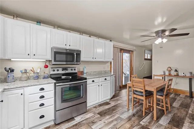 a kitchen with granite countertop a sink cabinets stainless steel appliances and a counter top space