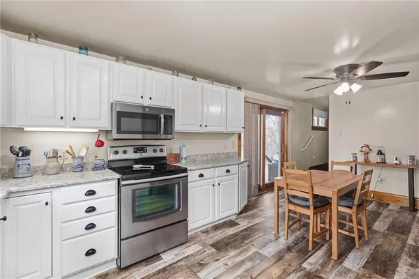 a kitchen with granite countertop a sink cabinets stainless steel appliances and a counter top space