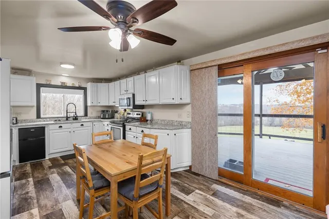 a kitchen with a refrigerator a stove top oven a sink and a large window