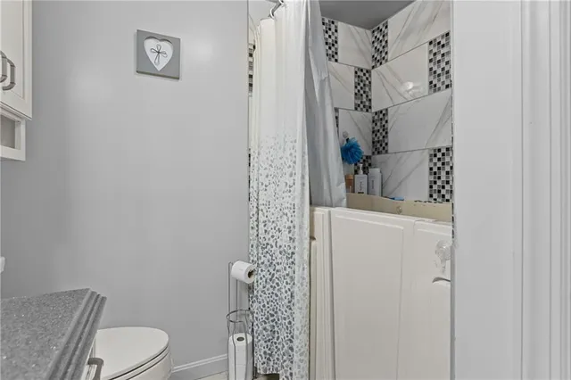 a bathroom with a toilet and a shower curtain