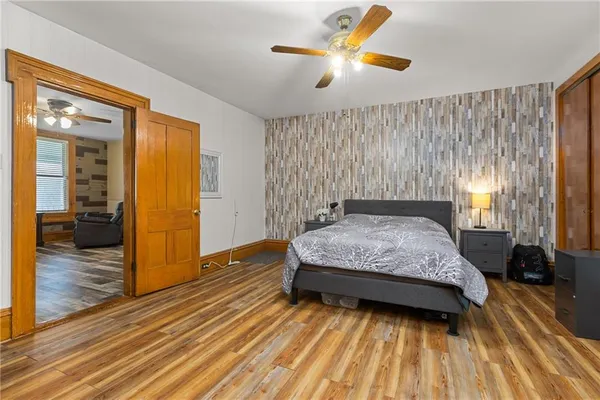 a bedroom with a bed and wooden floor