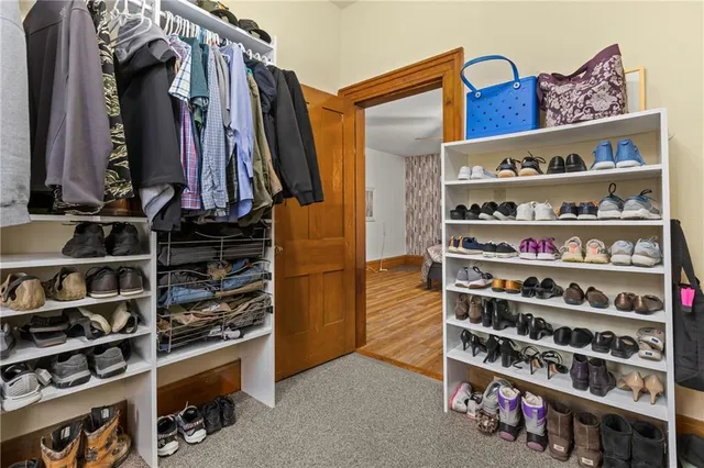 a view of walk in closet with clothes and shoes